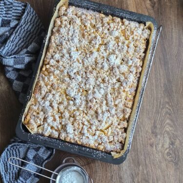 Softer Apfelkuchen mit Nuss-Streuseln – Saftig, aromatisch und perfekt für jede Jahreszeit 9 Apfelkuchen komplett gebacken mit Puderzucker