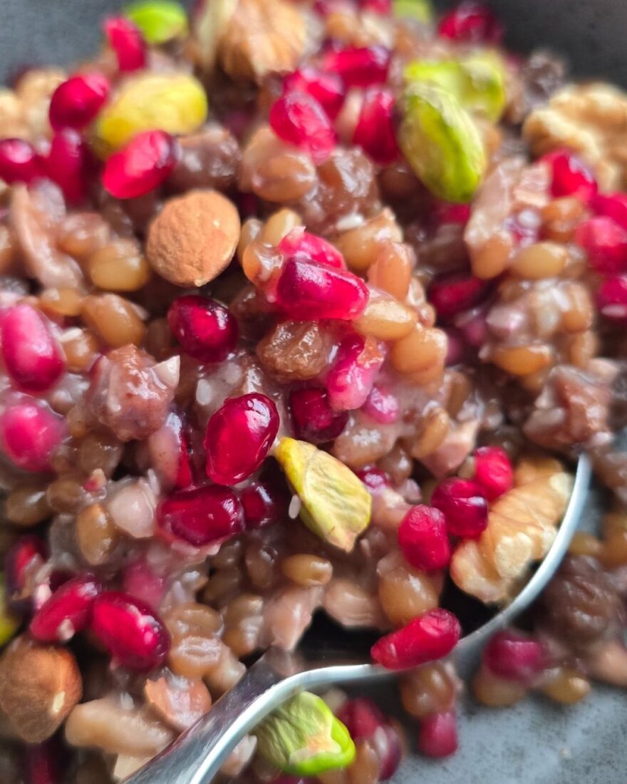 Löffel mit Asure Dessert, Nüssen und Granatapfelkernen in Nahaufnahme