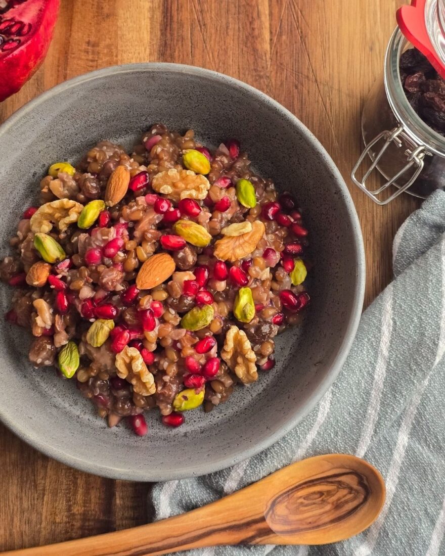 Fertiges Asure Dessert in grauer Schüssel mit Nüssen und Granatapfelkernen