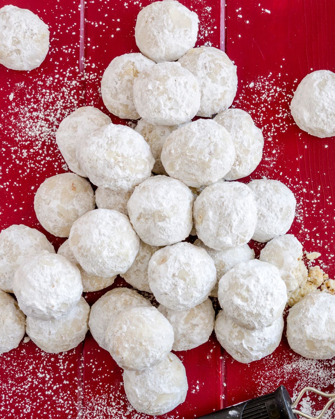 Griechische Kourabiedes – zart mürbe Butterkekse mit Puderzucker auf rotem Untergrund