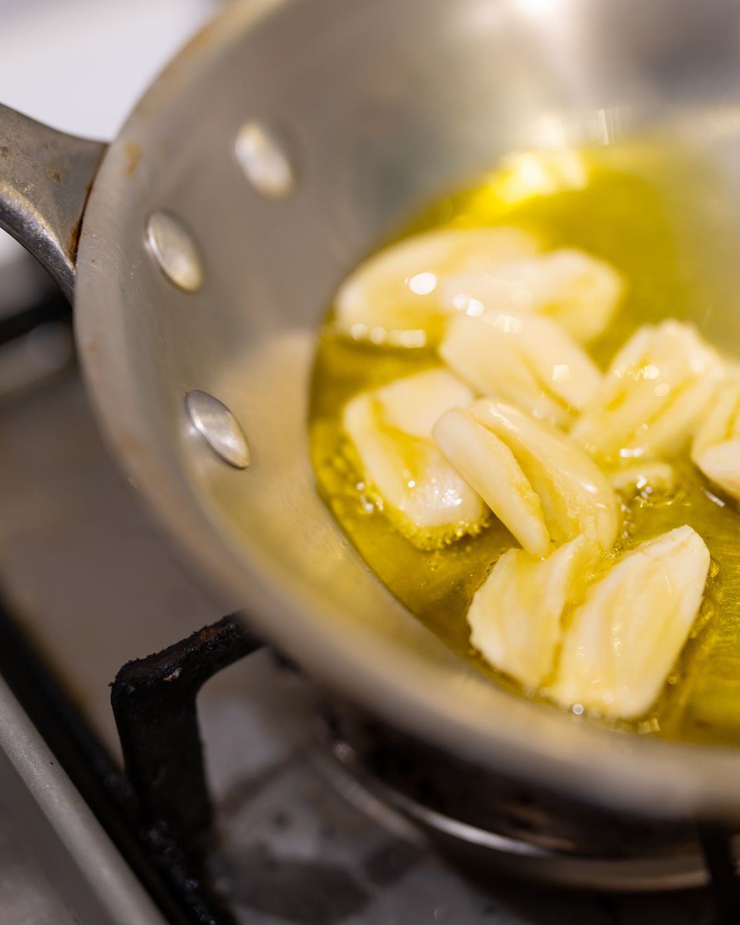 Olivenöl in der mediterranen Küche – Knoblauch wird in Olivenöl erhitzt und verleiht Gerichten intensives Aroma.