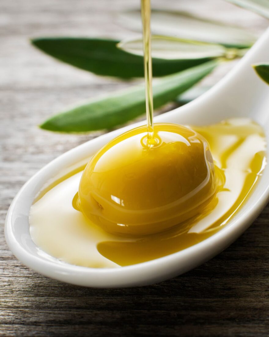 Olivenöl auf nüchternen Magen: Gesunde Morgenroutine mit Tradition 5 Olive auf einem Löffel mit nativem Olivenöl extra – Symbol für die gesunde Morgenroutine auf nüchternen Magen